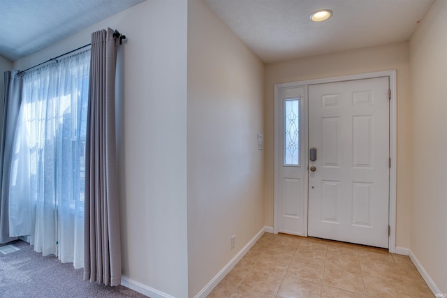 foyer featuring light tile patterned flooring and baseboards