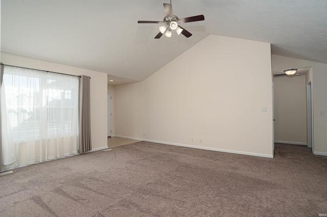 empty room featuring carpet floors, vaulted ceiling, and baseboards