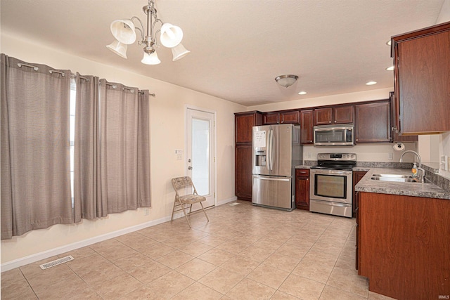 kitchen featuring stainless steel appliances, light tile patterned flooring, a sink, and visible vents