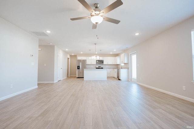 unfurnished living room with baseboards, recessed lighting, and light wood-style floors