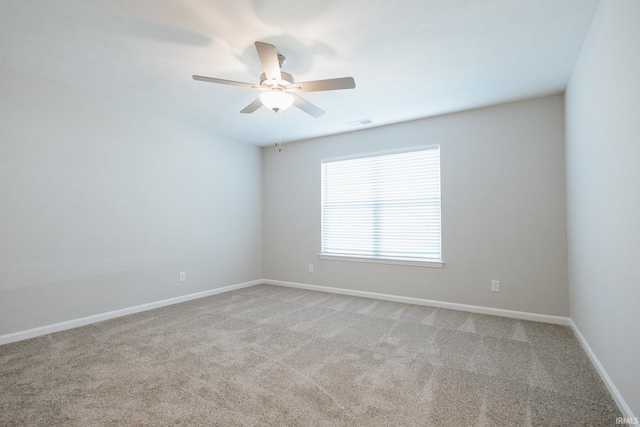 unfurnished room featuring visible vents, light carpet, a ceiling fan, and baseboards