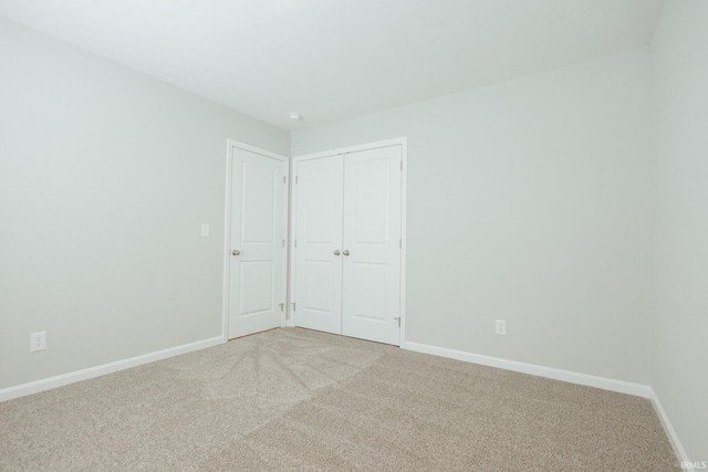 unfurnished bedroom featuring carpet floors, a closet, and baseboards