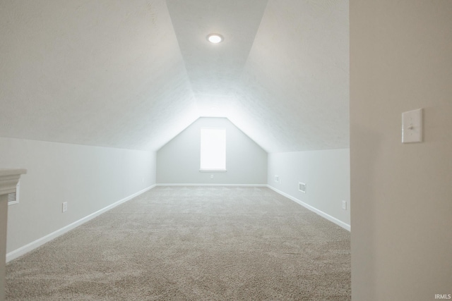 bonus room featuring lofted ceiling, carpet floors, and baseboards