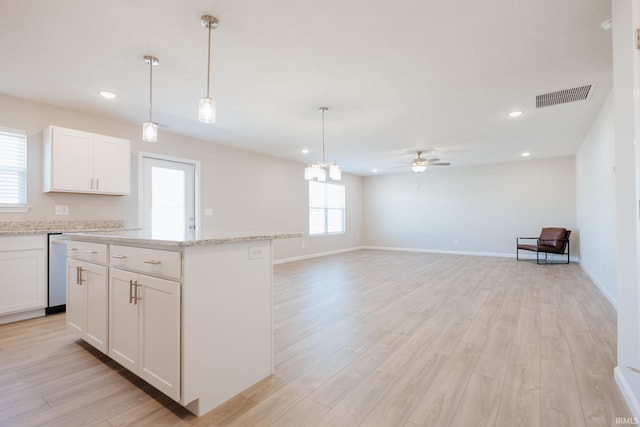 kitchen featuring light wood finished floors, a kitchen island, visible vents, and white cabinets