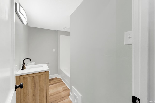 full bathroom featuring baseboards, visible vents, wood finished floors, and vanity