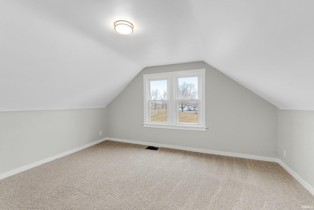 bonus room featuring carpet floors, visible vents, vaulted ceiling, and baseboards