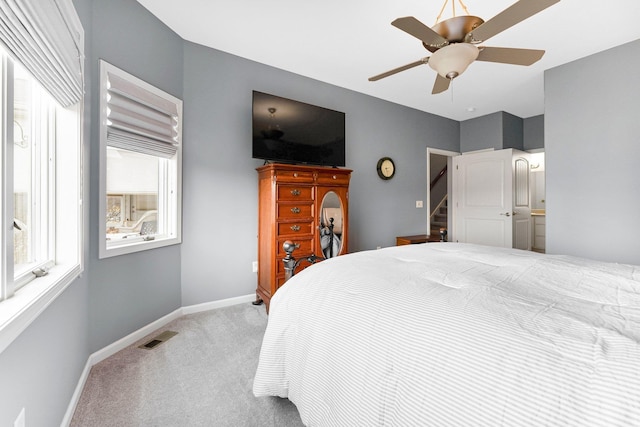 bedroom with baseboards, ceiling fan, visible vents, and light colored carpet