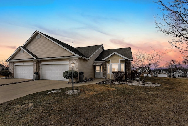 view of front facade with concrete driveway, a lawn, and an attached garage