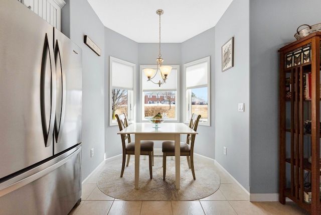 dining area featuring baseboards, light tile patterned flooring, and an inviting chandelier