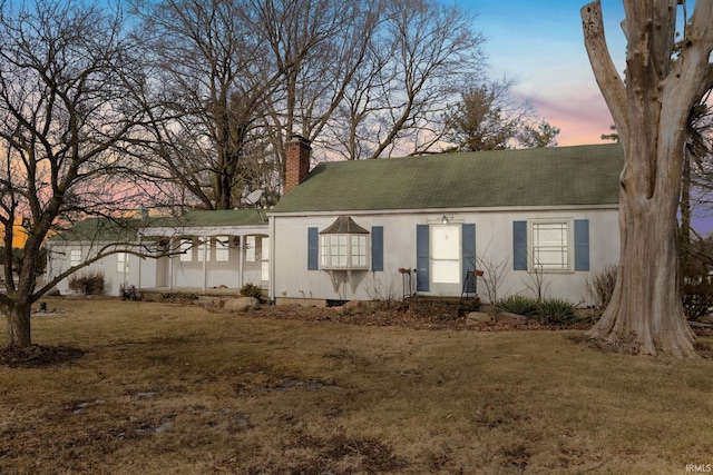 view of front of property with a chimney and a front lawn