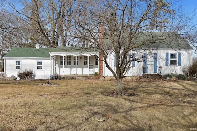 view of front facade with a front lawn and a chimney