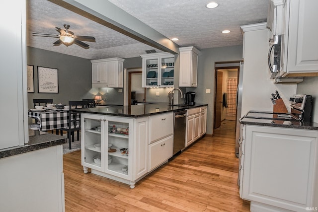 kitchen with light wood-type flooring, white cabinets, stainless steel appliances, and a sink