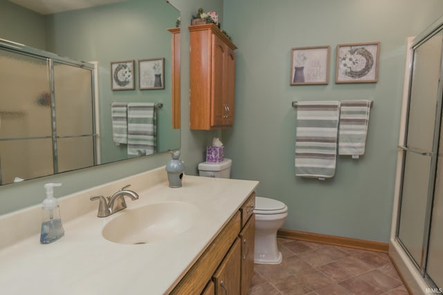 full bathroom with toilet, baseboards, an enclosed shower, and vanity