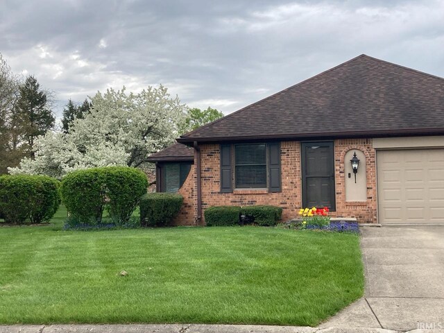 view of front of property with a front yard, brick siding, an attached garage, and roof with shingles