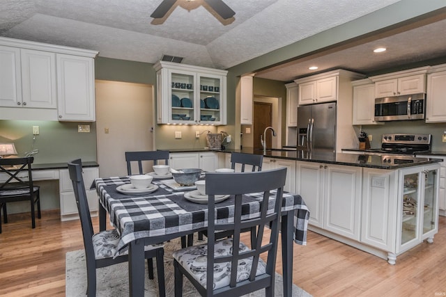 dining room featuring light wood finished floors, visible vents, ceiling fan, a textured ceiling, and recessed lighting