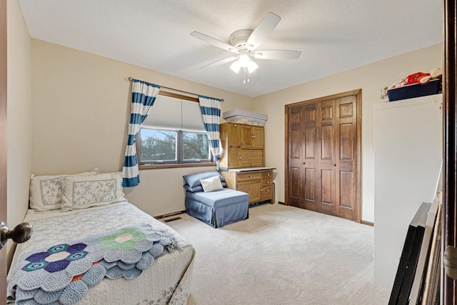 carpeted bedroom featuring a closet, ceiling fan, and a textured ceiling