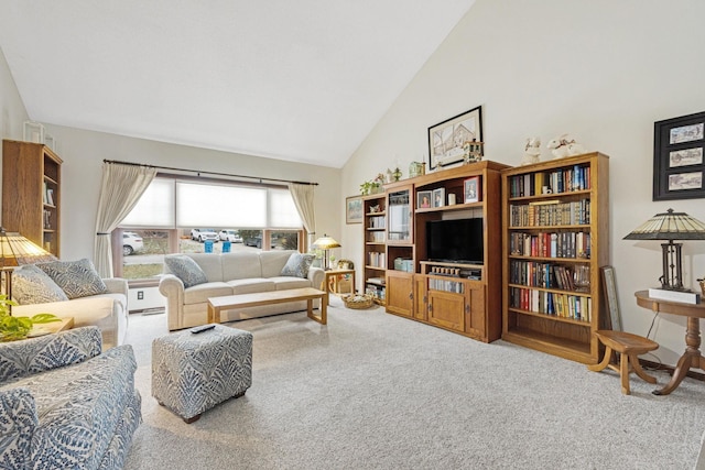 carpeted living area with high vaulted ceiling