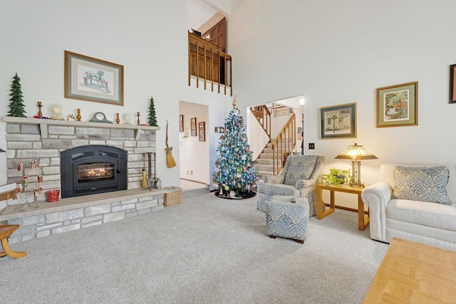 living area featuring carpet, a fireplace, a towering ceiling, baseboards, and stairs