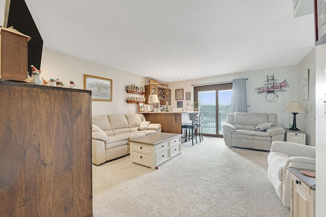 living room with a bar, a textured ceiling, and light colored carpet