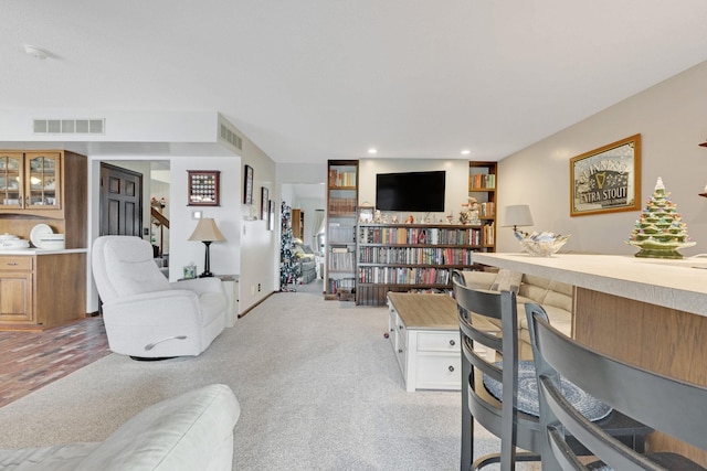 living room featuring recessed lighting, visible vents, and light carpet