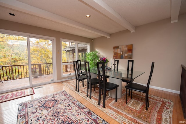 dining area with beam ceiling, visible vents, baseboards, and hardwood / wood-style floors