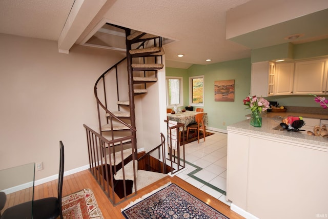 stairs featuring recessed lighting, wood-type flooring, beam ceiling, and baseboards