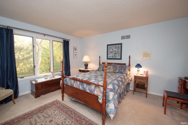 carpeted bedroom with a textured ceiling, visible vents, and baseboards