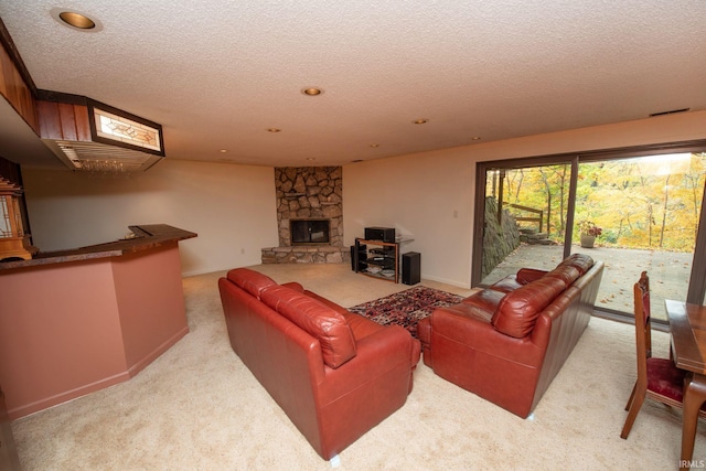 living area featuring a fireplace, a textured ceiling, and carpet flooring