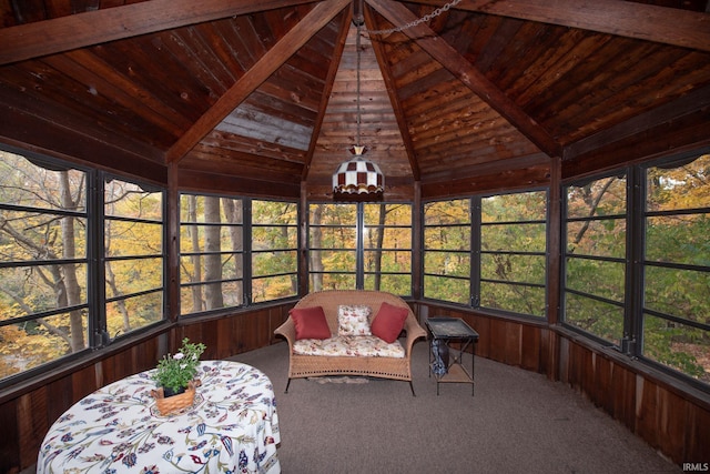 sunroom with lofted ceiling with beams, wooden ceiling, and a healthy amount of sunlight