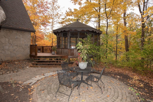 view of patio with a deck, outdoor dining space, and an outdoor structure