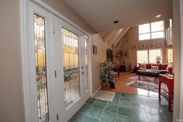 doorway featuring a textured ceiling, recessed lighting, dark tile patterned flooring, a fireplace, and baseboards