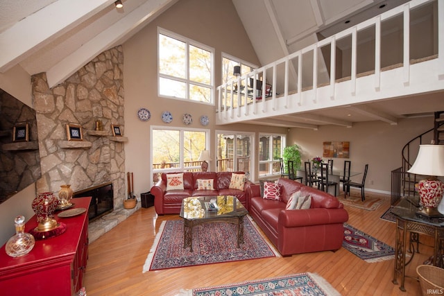 living room with a fireplace, high vaulted ceiling, beamed ceiling, baseboards, and hardwood / wood-style flooring