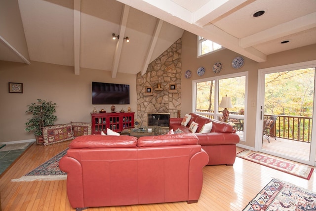 living area with high vaulted ceiling, wood-type flooring, a fireplace, and beamed ceiling