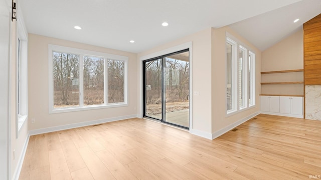 unfurnished room featuring a wealth of natural light, wood finished floors, and recessed lighting