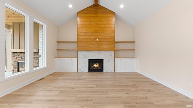 unfurnished living room featuring recessed lighting, light wood-style flooring, baseboards, and a premium fireplace