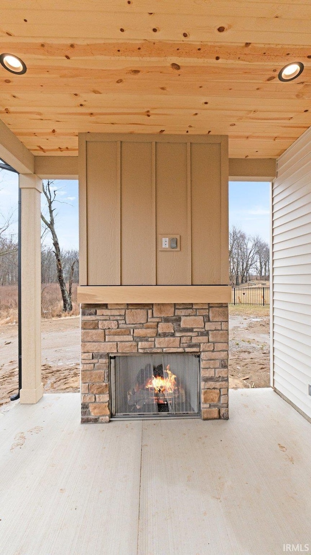 interior details with an outdoor stone fireplace and recessed lighting