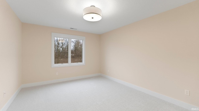 unfurnished room with baseboards and light colored carpet