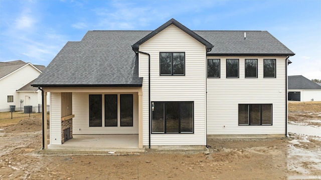 rear view of house featuring roof with shingles, a patio area, fence, and central air condition unit