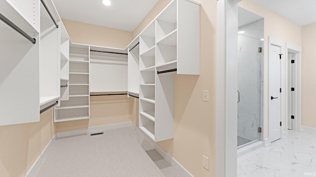 spacious closet with marble finish floor and visible vents