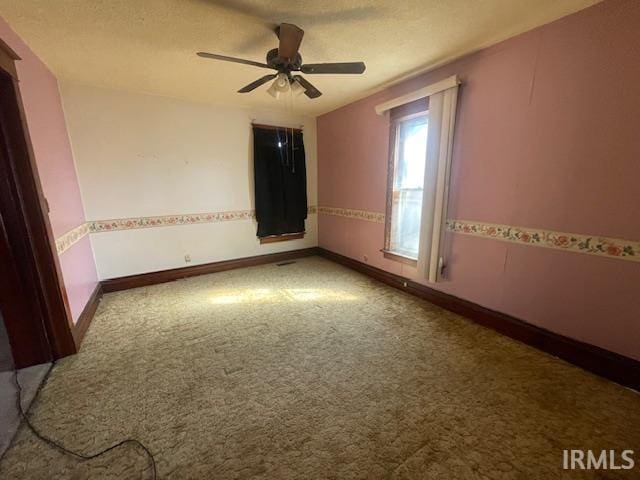 carpeted spare room with a ceiling fan, a textured ceiling, and baseboards