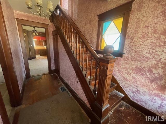 staircase featuring visible vents and a notable chandelier