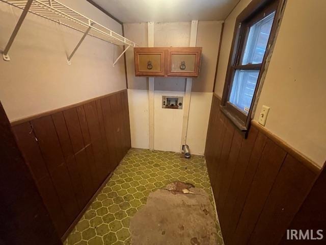 laundry area featuring washer hookup, a wainscoted wall, and wooden walls