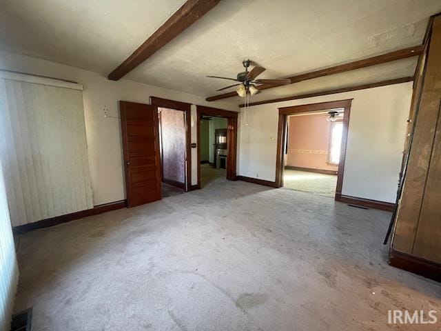 interior space featuring visible vents, a ceiling fan, beam ceiling, and baseboards