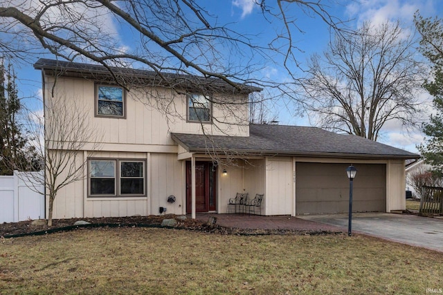 traditional-style house with a shingled roof, concrete driveway, fence, a garage, and a front lawn