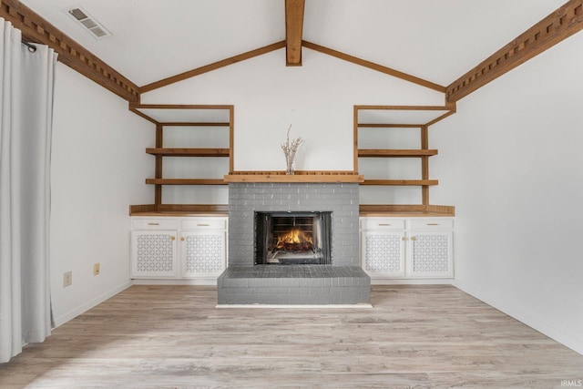 unfurnished living room featuring lofted ceiling with beams, a brick fireplace, visible vents, and light wood-style floors