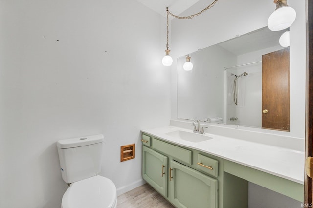 full bathroom featuring toilet, a shower, wood finished floors, and vanity