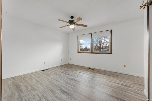 unfurnished room featuring visible vents, baseboards, and wood finished floors