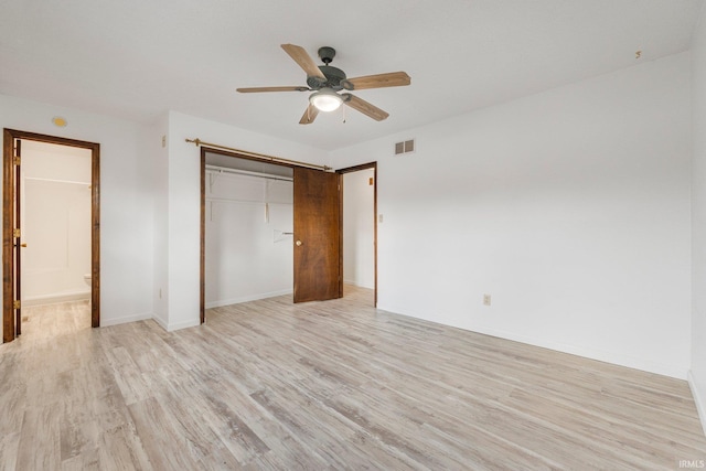 unfurnished bedroom with visible vents, ensuite bath, ceiling fan, light wood-style floors, and a closet