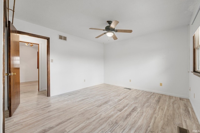 empty room with light wood-style floors, visible vents, and a ceiling fan