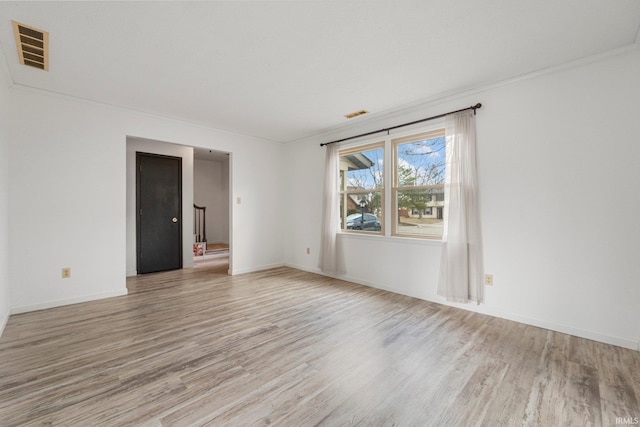 unfurnished room with light wood-style flooring, visible vents, and baseboards